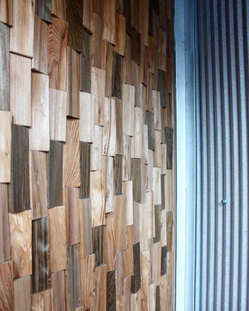Exterior remodel with wood entry door and metal panel siding.