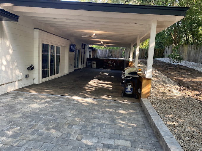 Enclosed back porch addition with covered parking area.