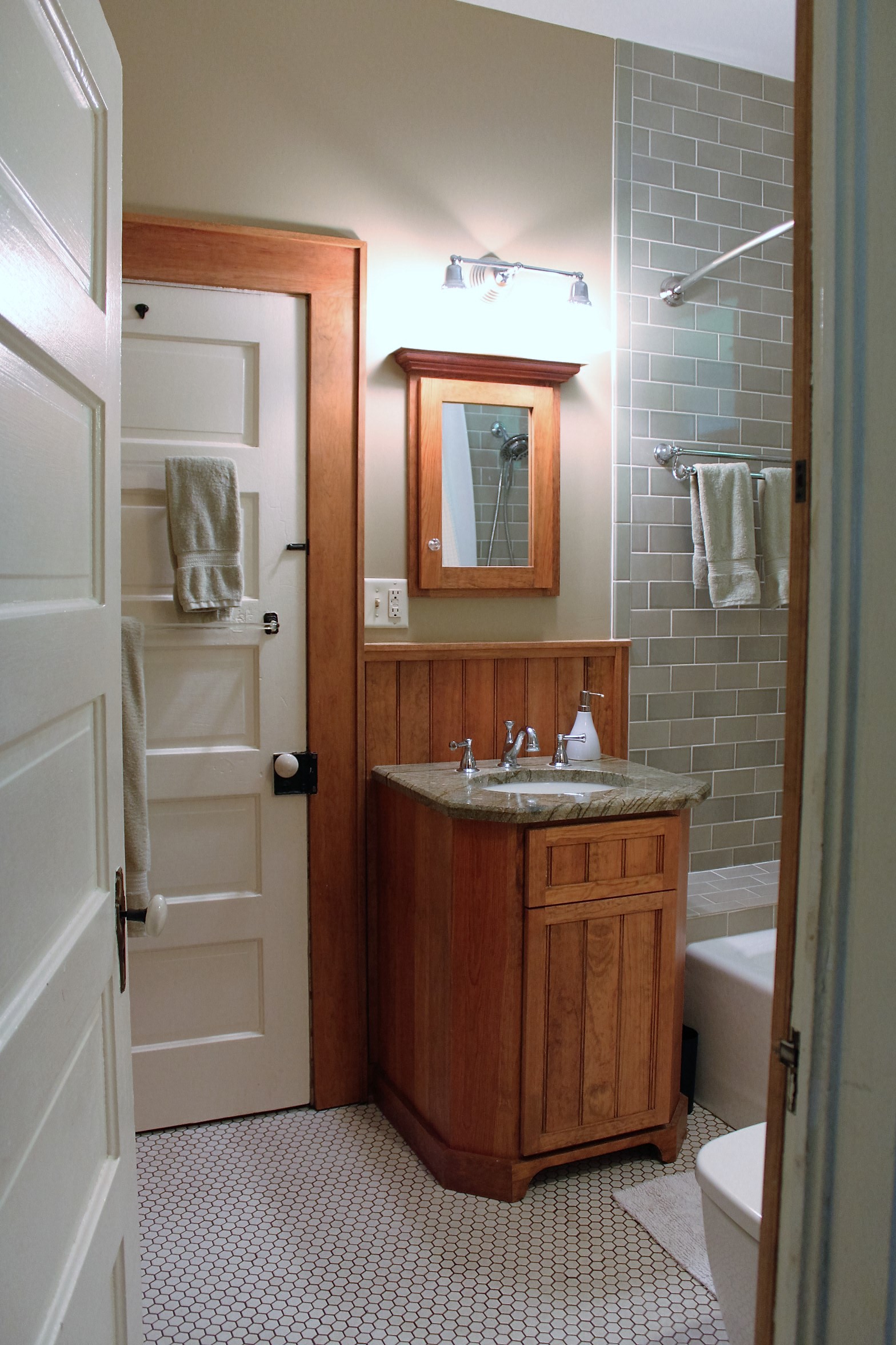 Bathroom renovation with upgraded vanity and tiled shower wall.