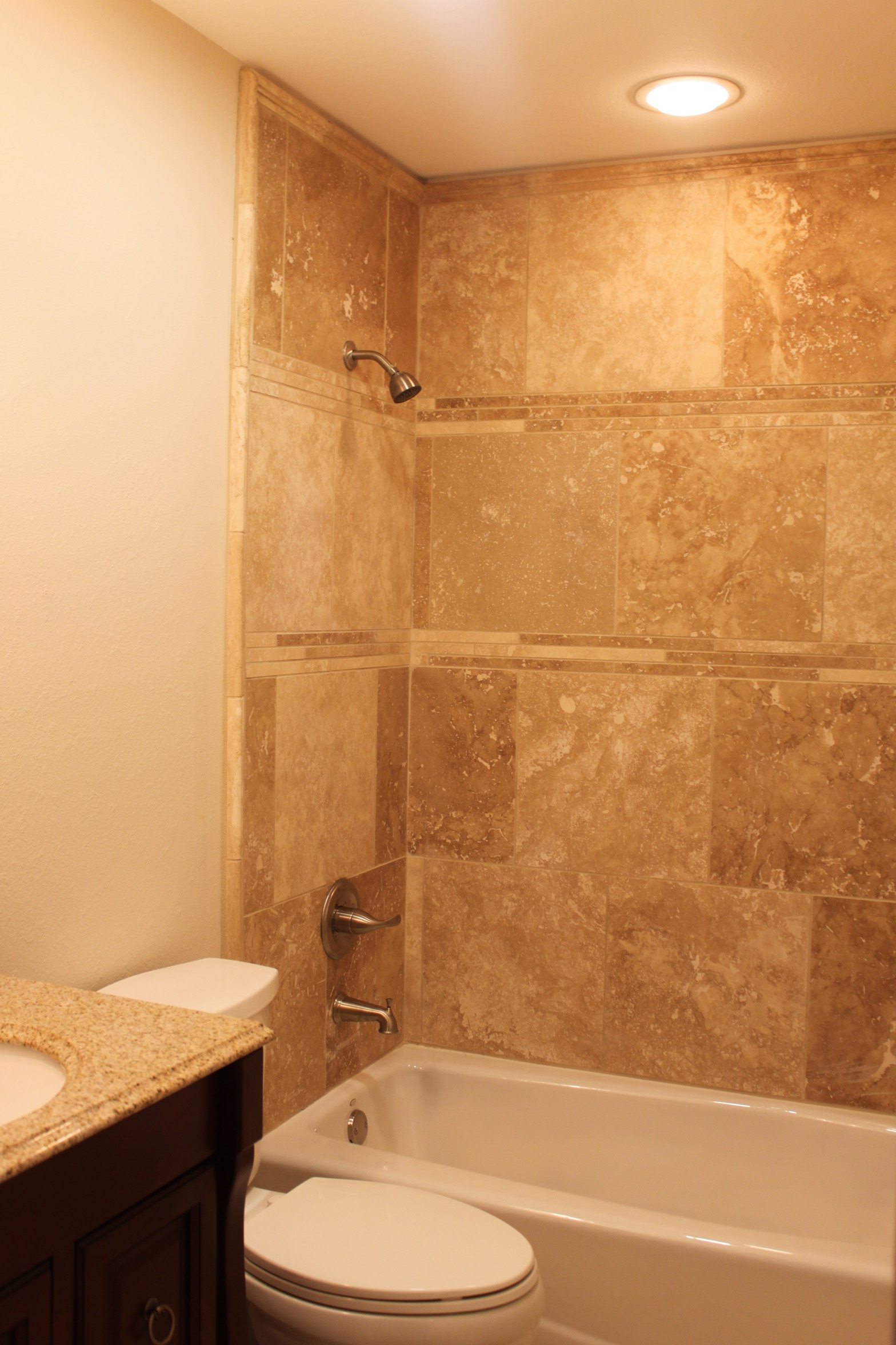 Bathroom shower renovation with travertine stone tile finish.